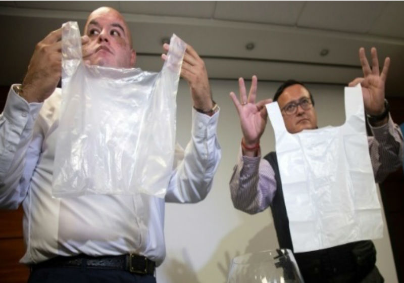 Engenheiros mostram as duas sacolas: uma de plástico e outra biodegradável Foto: AFP
